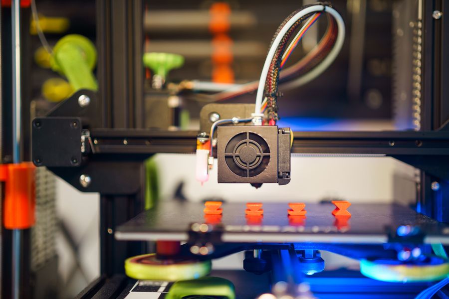 3D-printer print oranje onderdelen in serie
